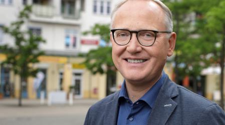 Portraitfoto von Klaus Mindrup vor Straßenkulisse