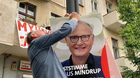 Klaus hängt eines seiner Wahlplakate auf mit der Aufschrift  "Erststimme Klaus Mindrup"