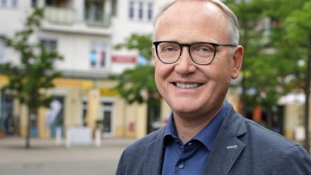 Portraitfoto von Klaus Mindrup vor Straßenkulisse