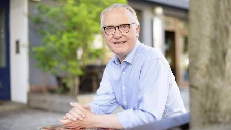 Klaus Mindrup sitzend auf einer öffentlichen Bank im Bezirk Pankow 